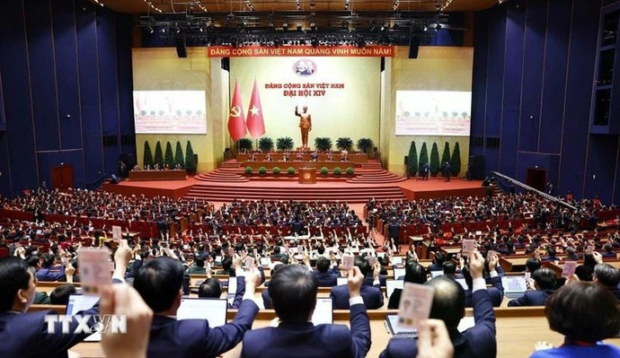 Les délégués votent l'adoption de la Résolution du XIVe Congrès national du Parti communiste vietnamien. (Photo : VNA)